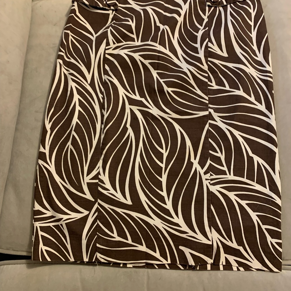 Brown knee length skirt with leaf patterns.